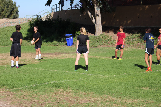 Some students pass the ball in a circle to practice for their upcoming season.