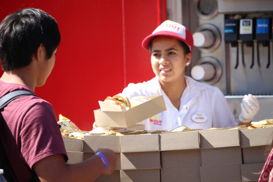 A friendly In-N-Out employee hands an honor roll student his lunch.