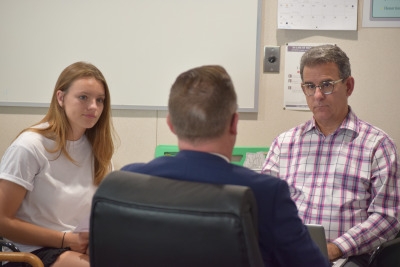 Junior Breegan Knudsen and Choir Director Michael Hayden listen to Principal Ben Dale share his ideas on the gravity of ones GPA.