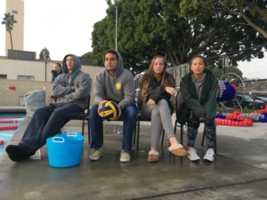 Girls JV and Frosh Water Polo coaches Damon and James sit on the bench and coach during the frosh game alongside two injured players. Both teams lost their games to Culver City at the Culver City Plunge.
