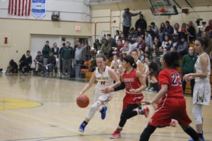 Herdman dribbles past her opponent in an attempt to create an open lane to the basket.