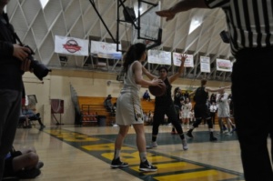 Junior Kira Escovar looks for an open teammate to pass the ball to after the opposing team hit the ball out of bounce. The girls basketball game was played at home in the Fischer gym at 6 pm on Thursday.