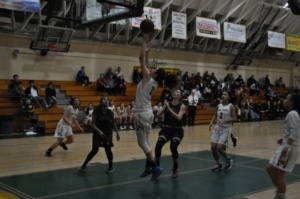 Junior Kira Escovar shoots the ball after driving past the other team towards the basket. This play resulted in Escovar scoring 2 points for the Mustangs, which helped Costa keep their lead against Edison. 