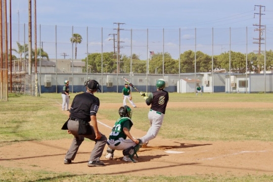 Junior Chris Penna prepares to make a run to first base after successfully hitting the ball. His teammate completed a home run as a result of his hit.