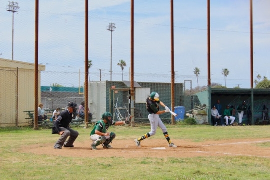 Sophomore Jared Karos follows through with his swing at the ball. He successful made a hit and advanced to first.