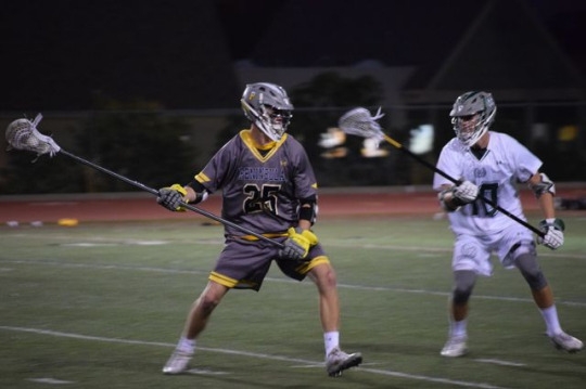 Peninsula varsity lacrosse player plays tough offense against Costa on Tuesday April 25. Costa player held his opponent at the top of the twelve line, so he will not get a shot on goal.